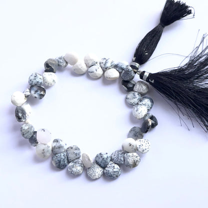 Stone beads in a strand of Dendrite Opal, highlighting their polished facets and unique patterns.