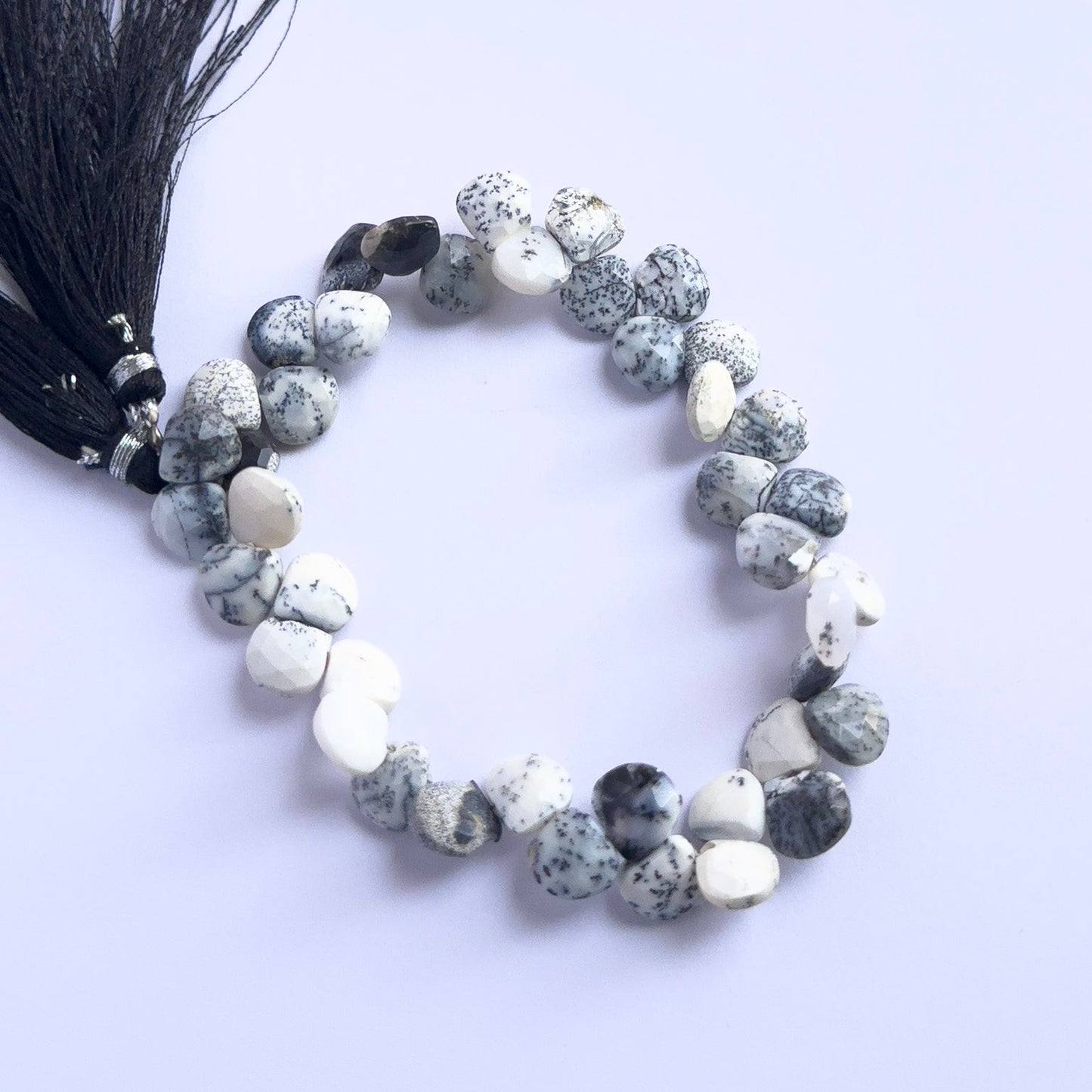 Handmade jewellery components featuring Dendrite Opal faceted briolette beads strung in a neat arrangement.