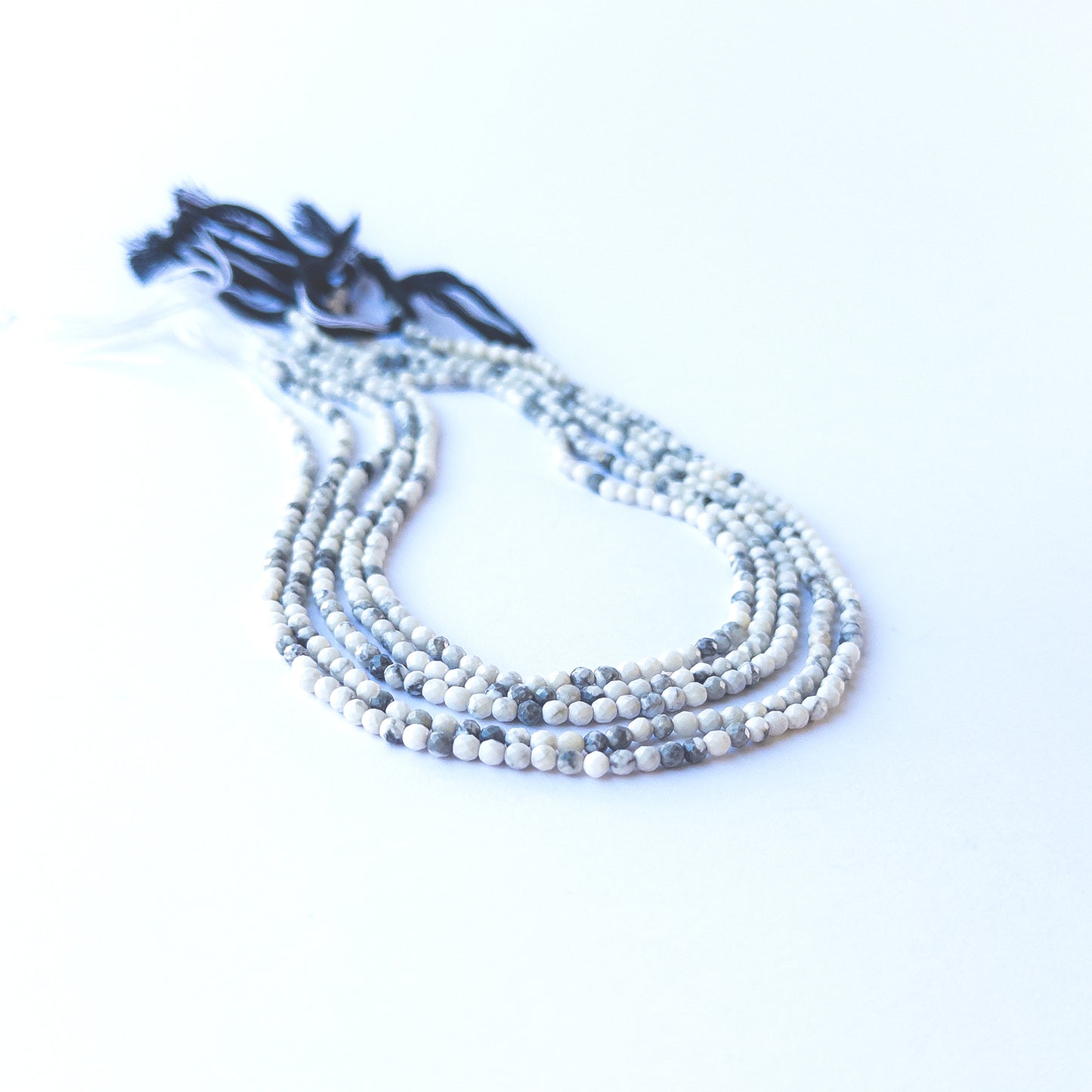 Dendrite Opal faceted rondelle beads displaying black‑and‑white inclusions and polished surfaces.