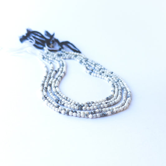 Dendrite Opal faceted rondelle beads displaying black‑and‑white inclusions and polished surfaces.