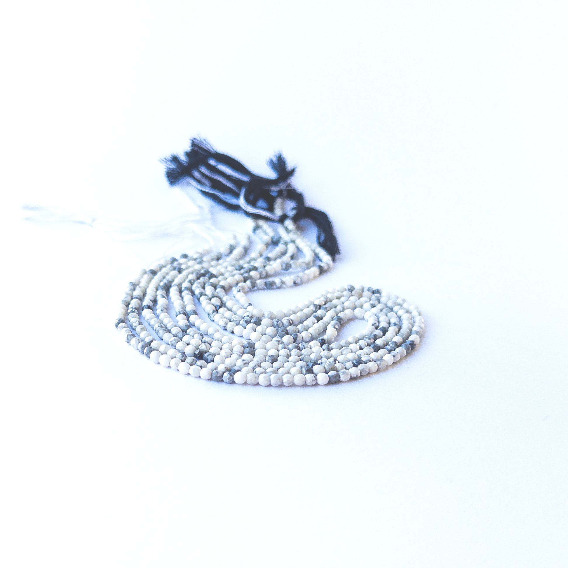 Close‑up of genuine Dendrite Opal faceted rondelle beads showing their natural dendritic patterns and shine.