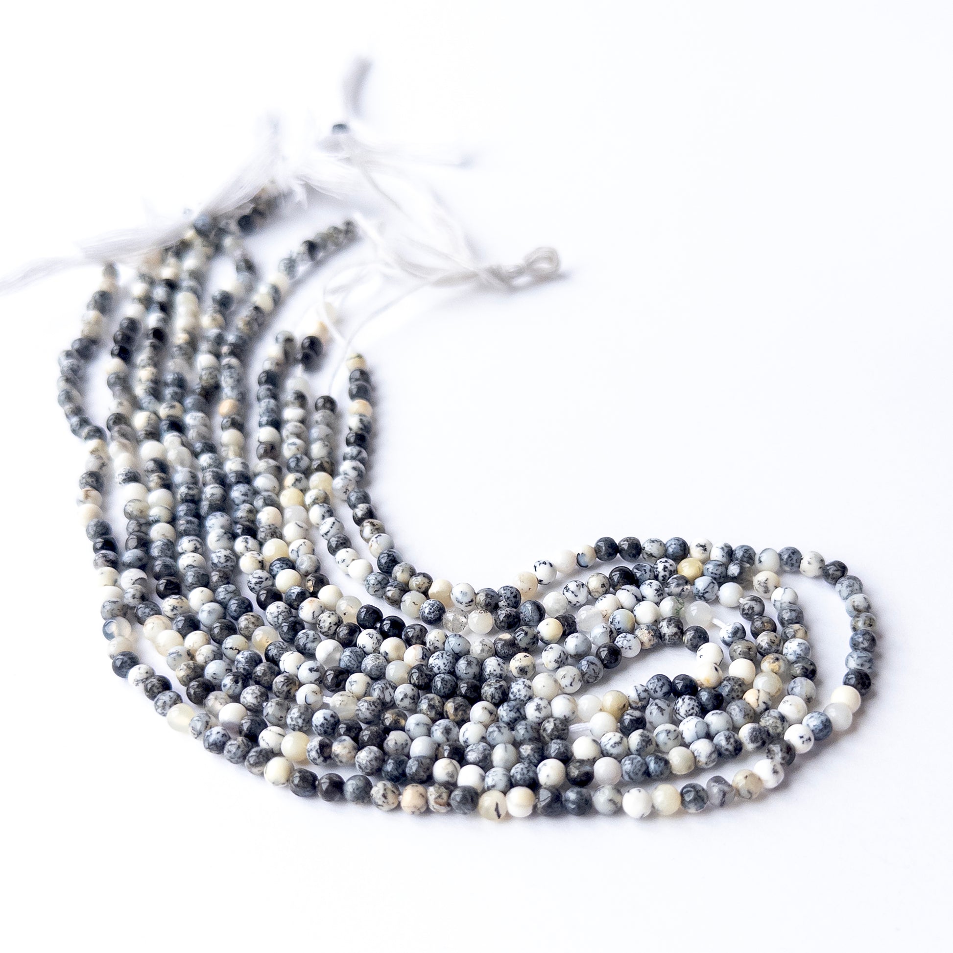 Genuine Dendrite Opal gemstone beads in smooth round cut, displaying polish, texture, and distinctive dendritic patterns.