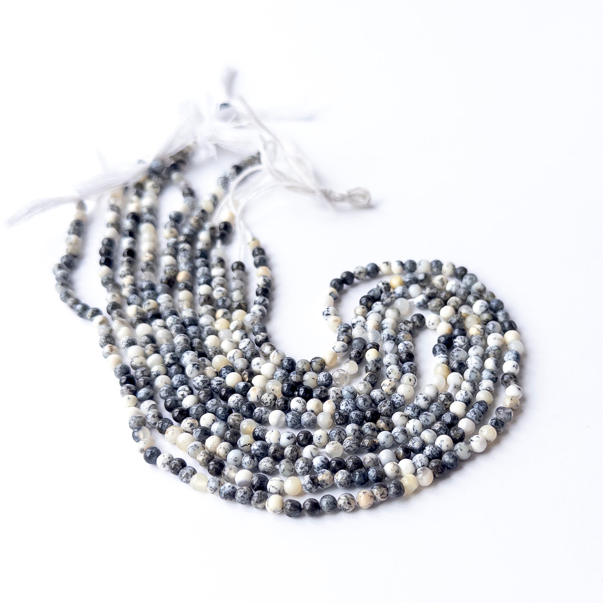 Dendrite Opal smooth round beads displayed in multiple strands, showing consistent 3.6mm sizing and natural variation.