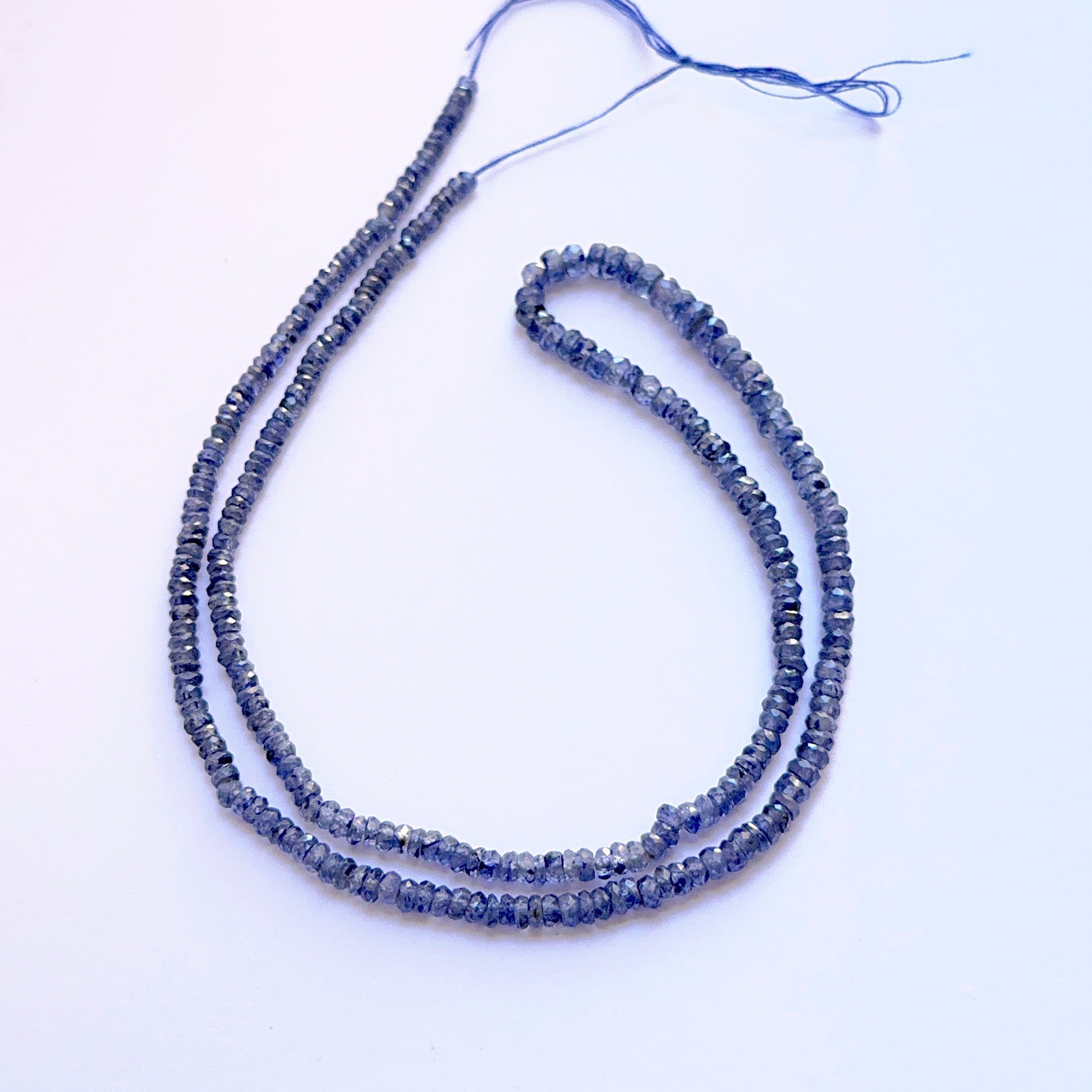 Strand of Blue Sapphire faceted rondelle beads 3–4mm ideal for layered necklaces and artisan DIY jewellery projects.
