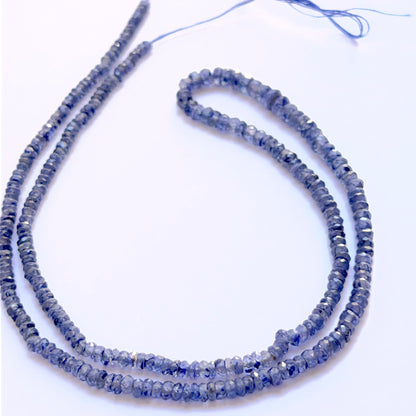 Blue Sapphire faceted rondelle 3–4mm beads arranged to display uniform shape and vivid sapphire hues.

