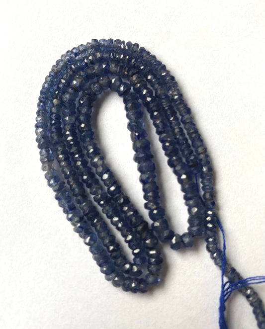 Denim Blue Sapphire faceted rondelle beads in deep indigo tones neatly arranged on a 43cm strand.