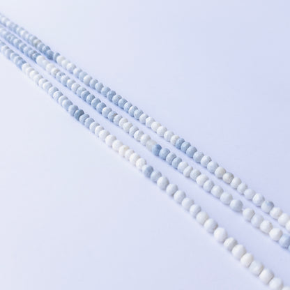 Denim Opal faceted rondelle beads displayed in multiple strands, showing consistent sizing and subtle colour shifts.