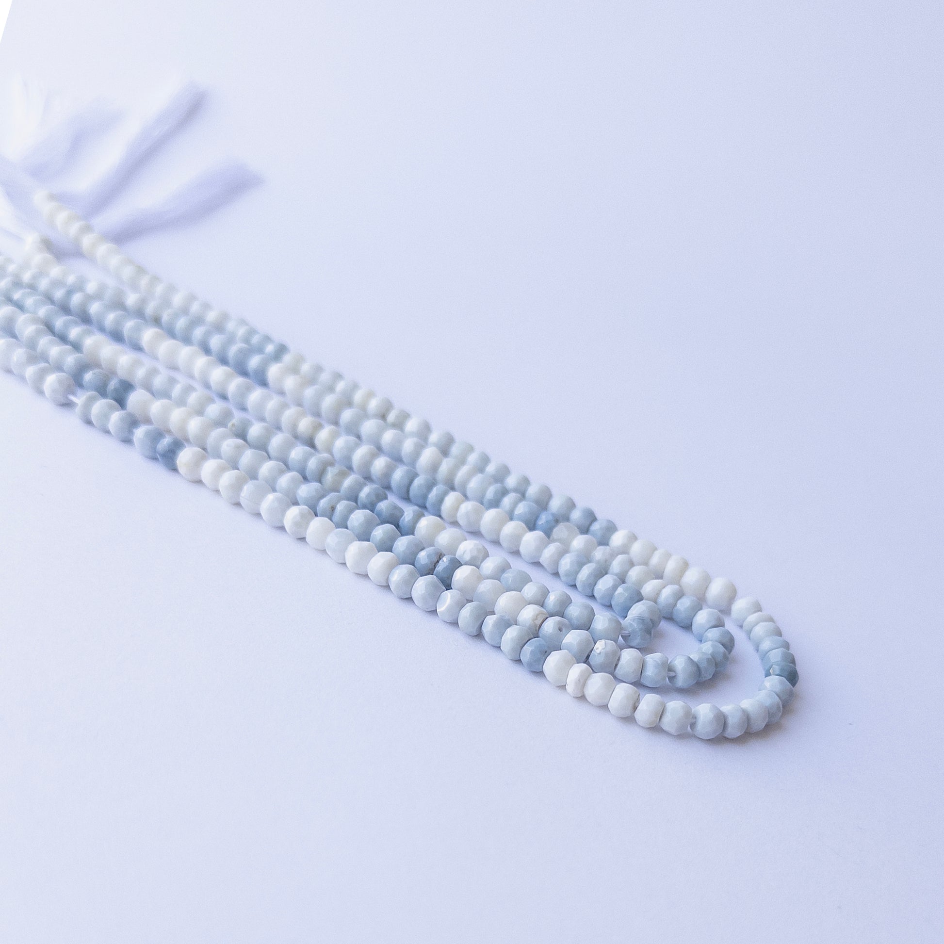 Genuine Denim Opal gemstone beads in faceted rondelle cut, displaying polish, texture, and natural beauty.