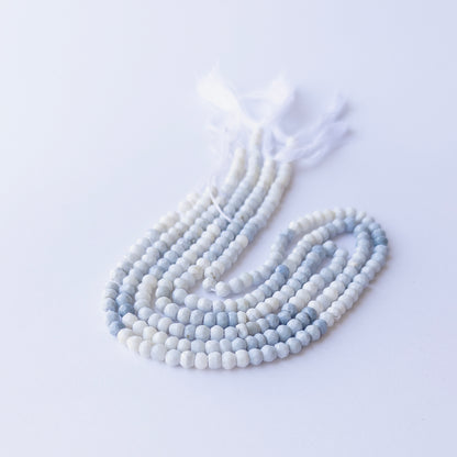 Strands of Denim Opal faceted rondelle gemstone beads arranged neatly, showcasing their fine cut and natural blue hues.