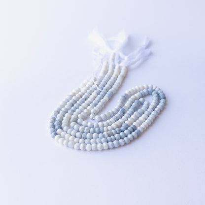 Genuine Denim Opal gemstone beads in faceted rondelle cut, displaying polish, texture, and natural beauty.