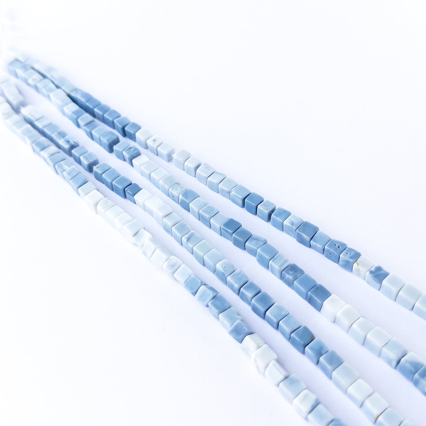 High‑quality Denim Opal smooth cube beads in 5mm size offering clarity and shine for artisan jewellery projects.
