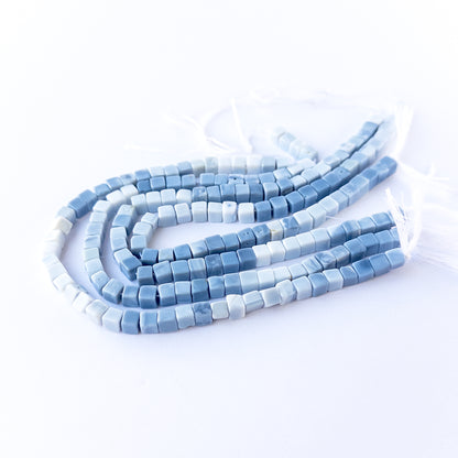 Authentic Denim Opal gemstone beads showcasing calming hues, smooth cube shaping and premium bead quality for jewellery designers.