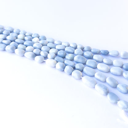 Handmade jewellery components featuring natural denim opal smooth tumbles with earthy blue tones.