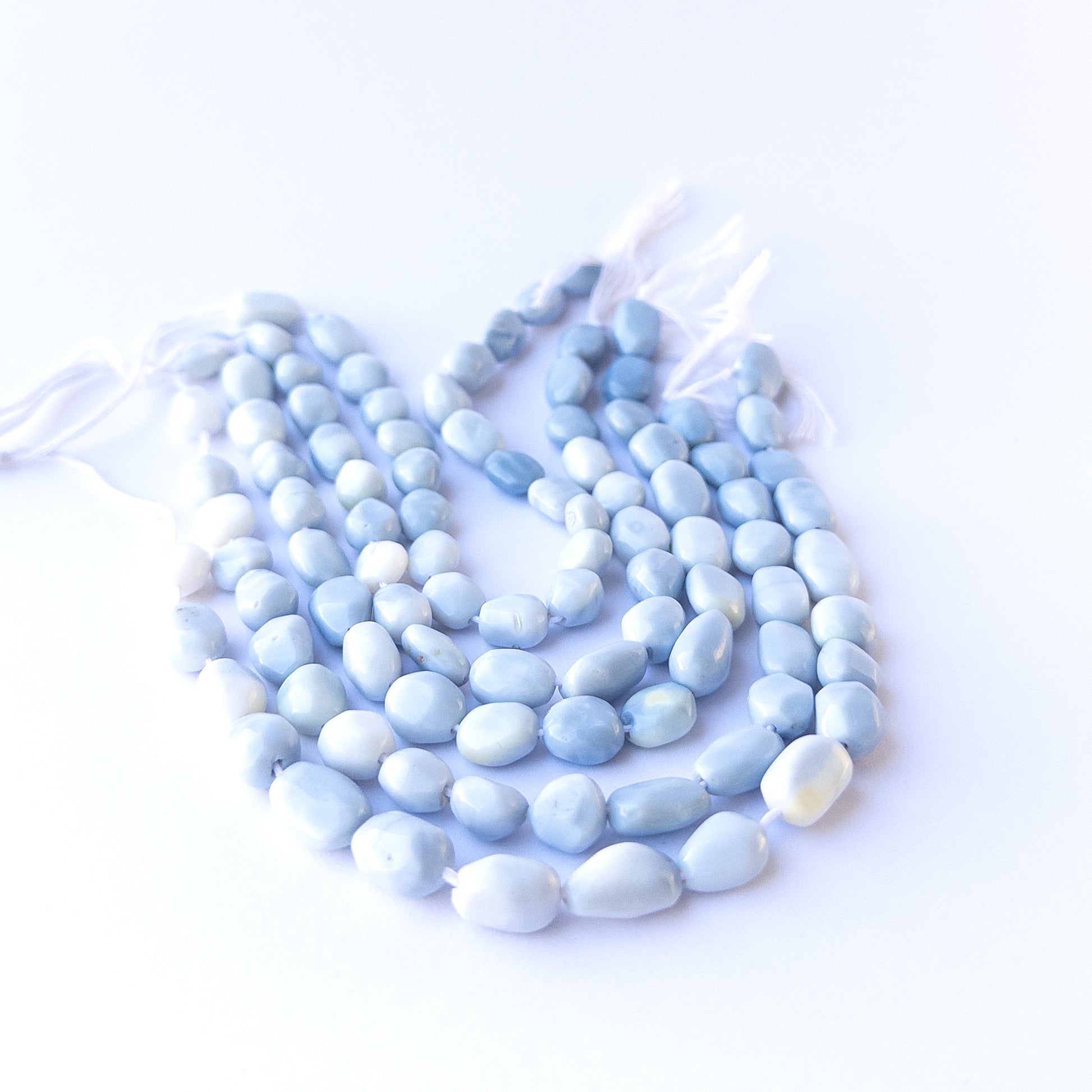 Authentic denim opal gemstone beads with polished smooth tumble cuts, ideal for handmade jewellery components.