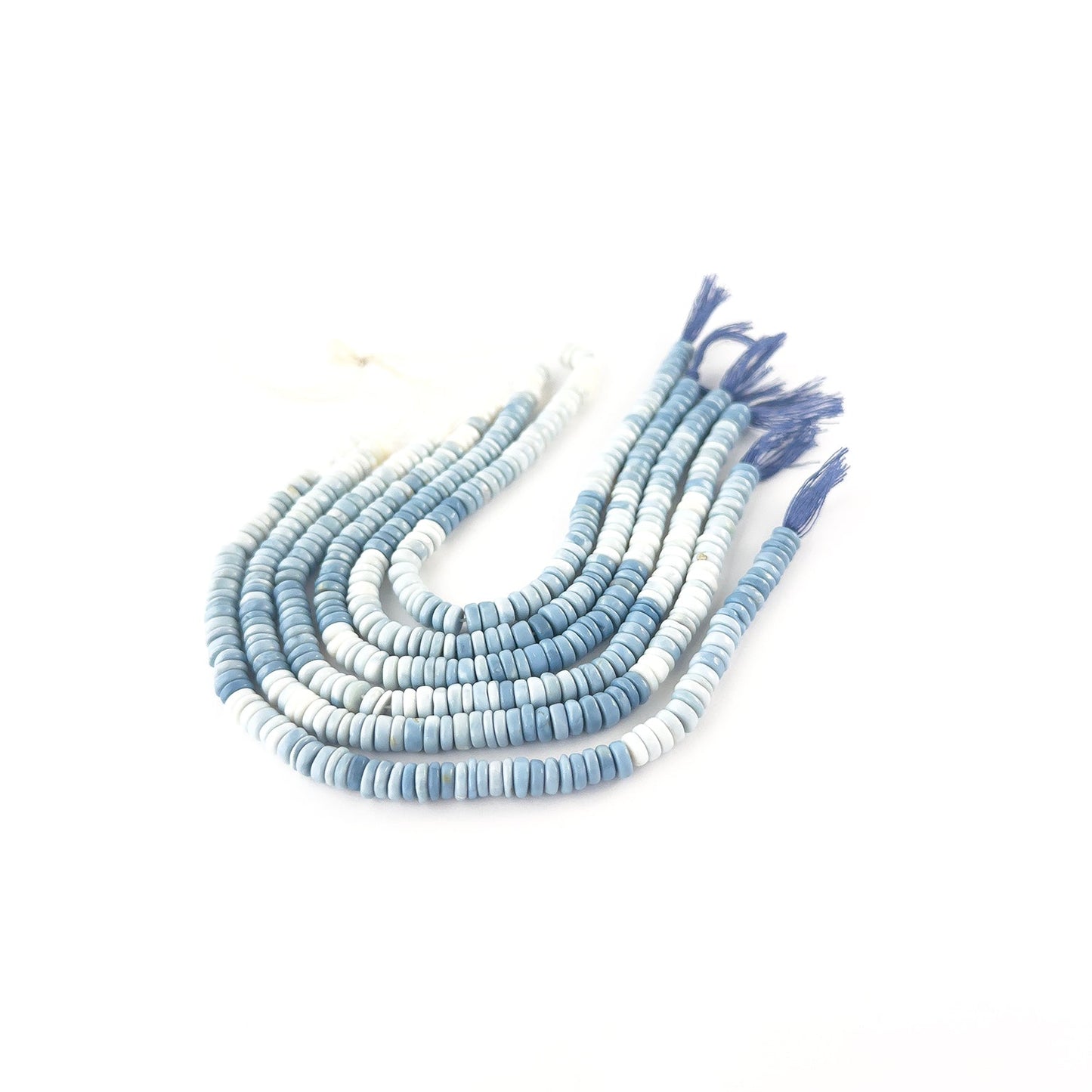 Denim Opal wheel beads featuring smooth surfaces and gentle blue shading in consistent 6–7mm sizing.