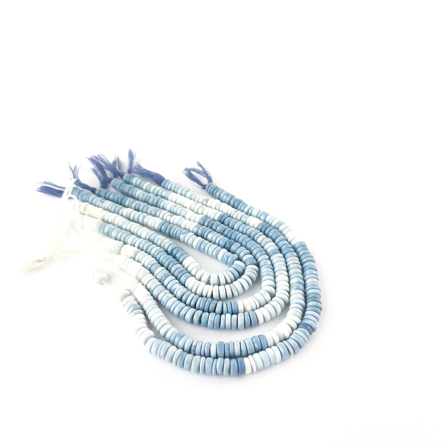 Close‑up of Denim Opal smooth wheel beads highlighting their rounded edges and layered blue tones.