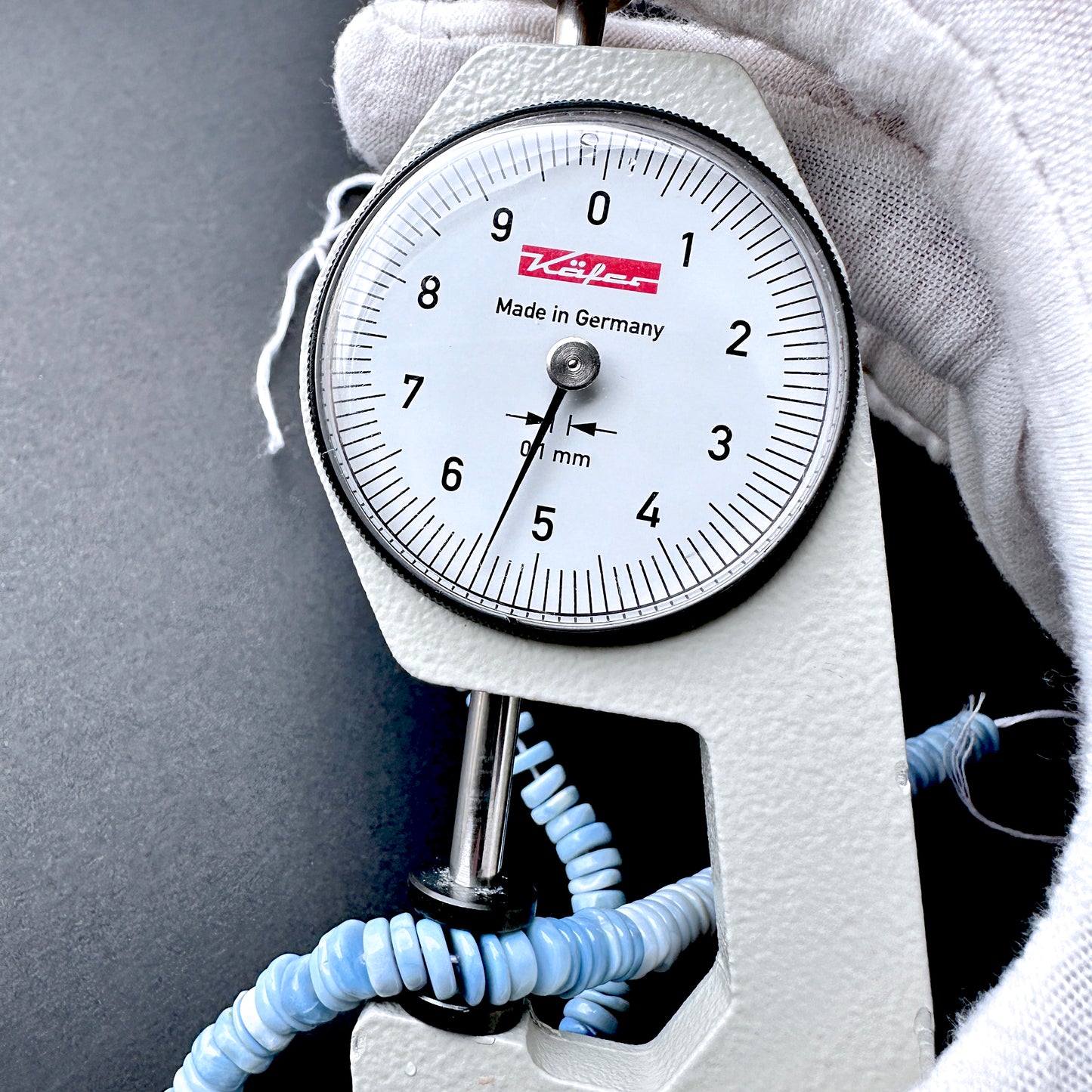 A dial gauge measures the Denim Opal wheel 5.5-5.7mm gemstone