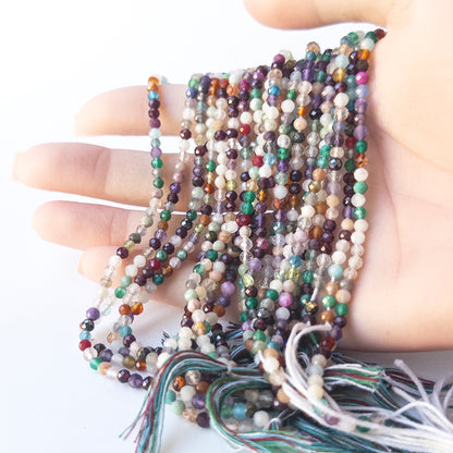 A person holds delicate strands of Disco beads, showcasing their faceted rondelle design.