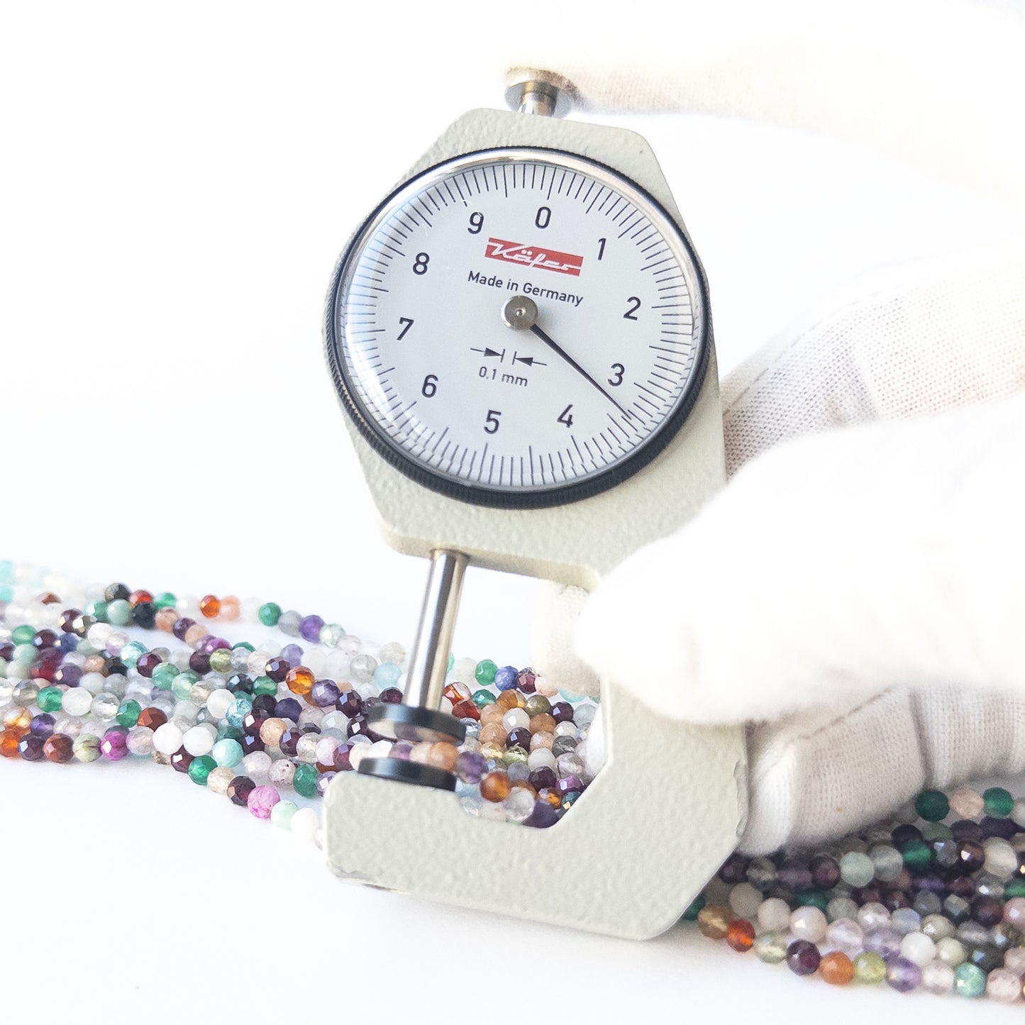 A dial gauge measures the Disco faceted rondelle 3.5mm gemstone.