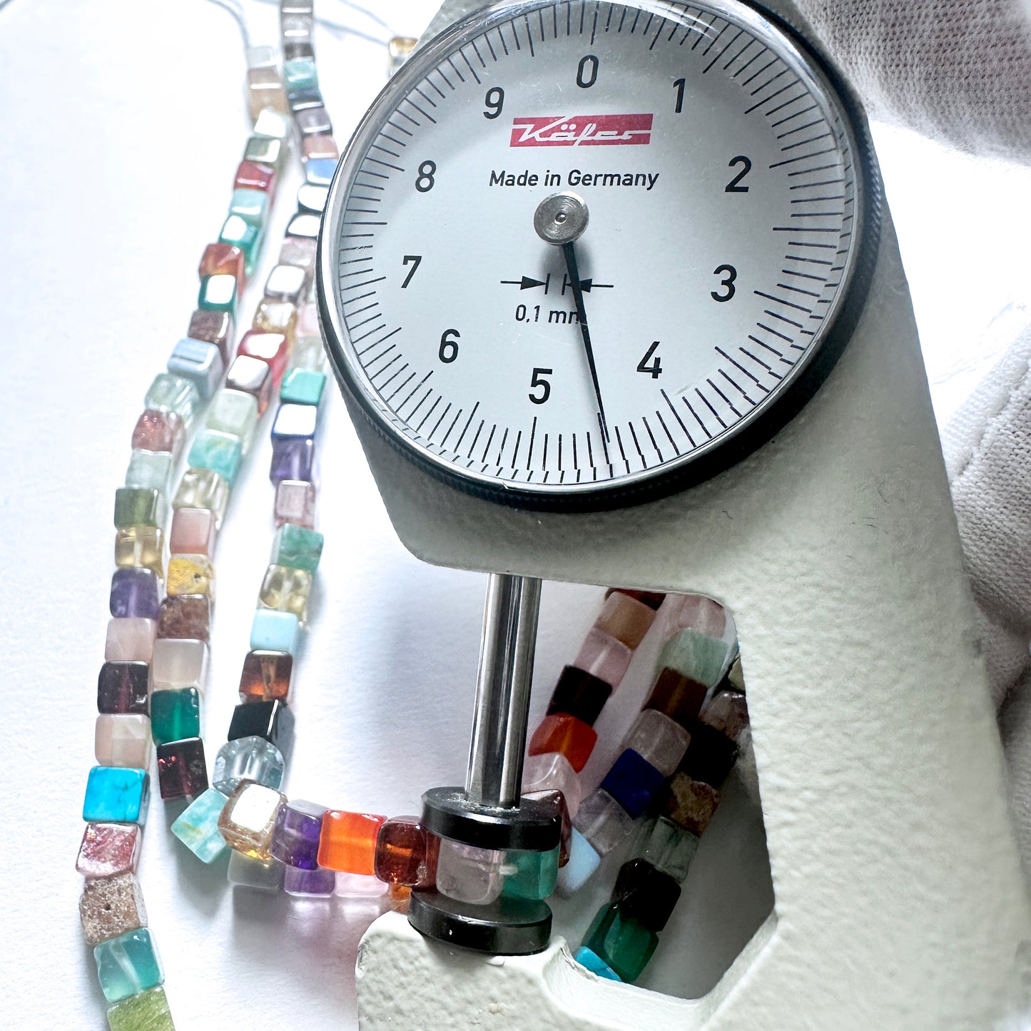 A dial gauge measures the Disco Smooth Square 4.3-4.5mm gemstone.