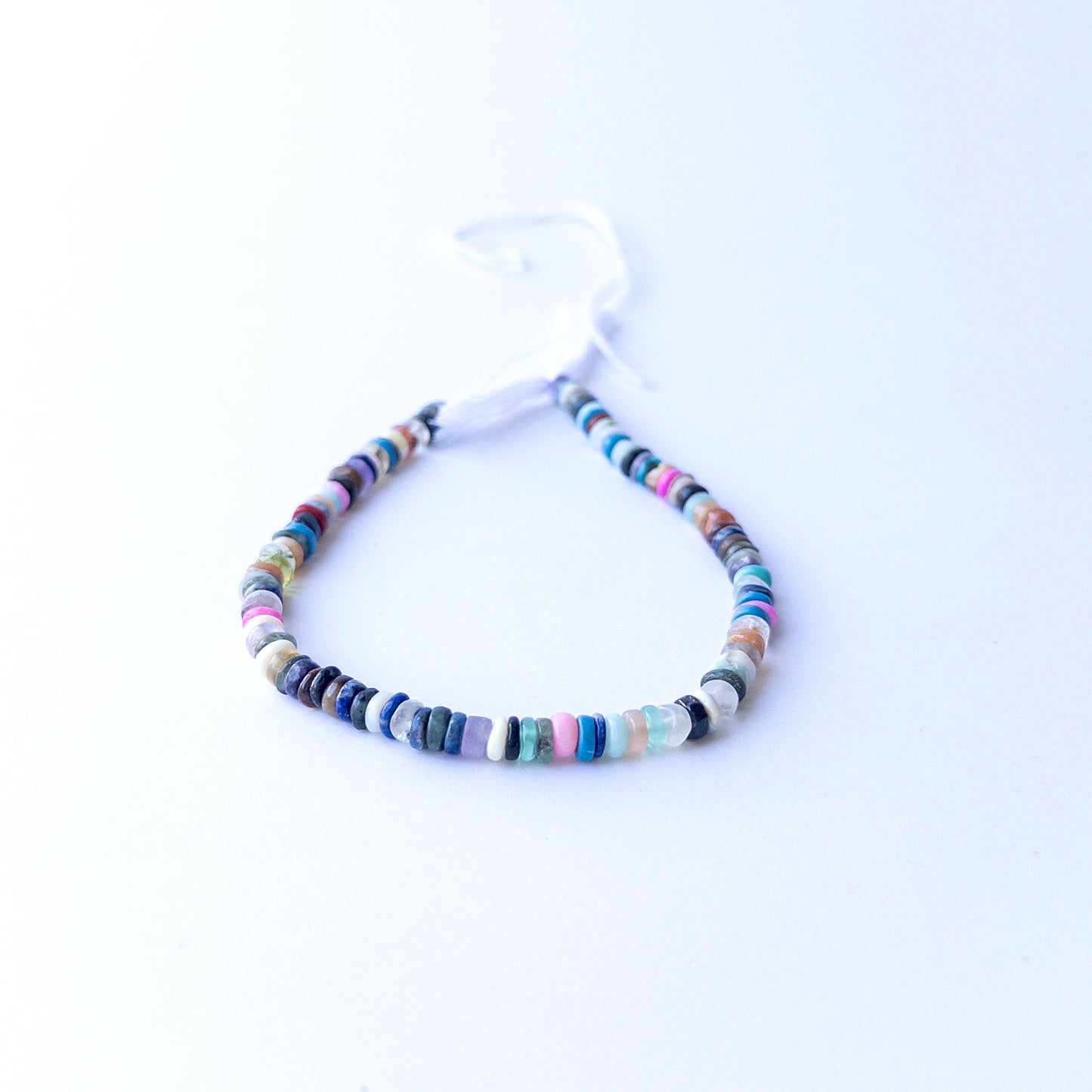 Strands of Disco smooth wheel heishi gemstone beads arranged neatly, showcasing their smooth finish and bright tones.
