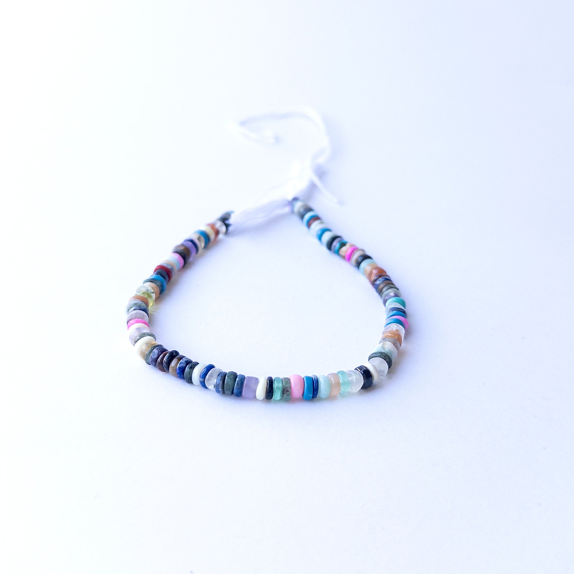 Strands of Disco smooth wheel heishi gemstone beads arranged neatly, showcasing their smooth finish and bright tones.