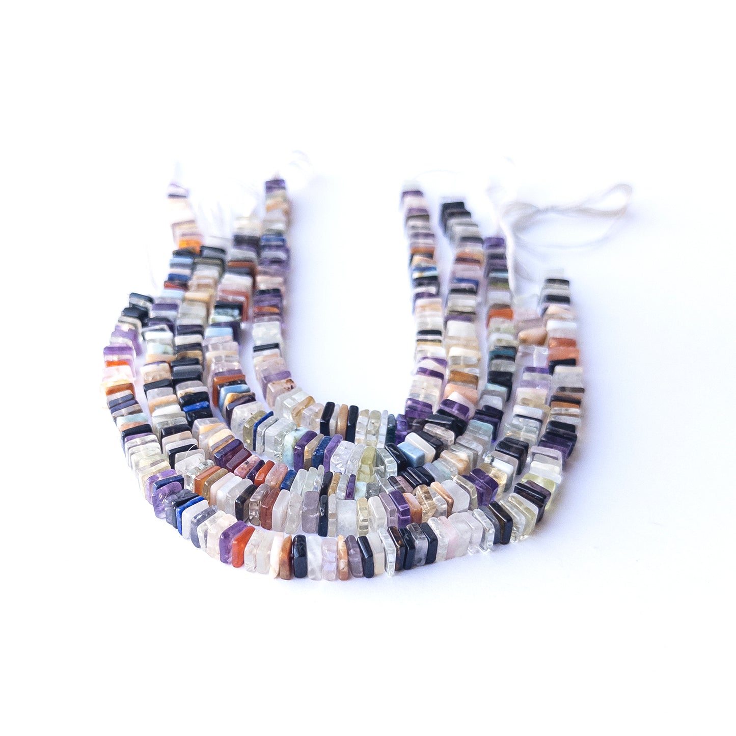 Close‑up of authentic Disco square heishi stone beads showing texture and shine for DIY jewellery making.