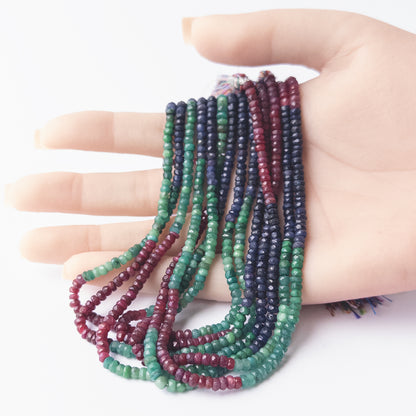 A person holds delicate strands of Dyed Corundum beads, showcasing their faceted rondelle design.