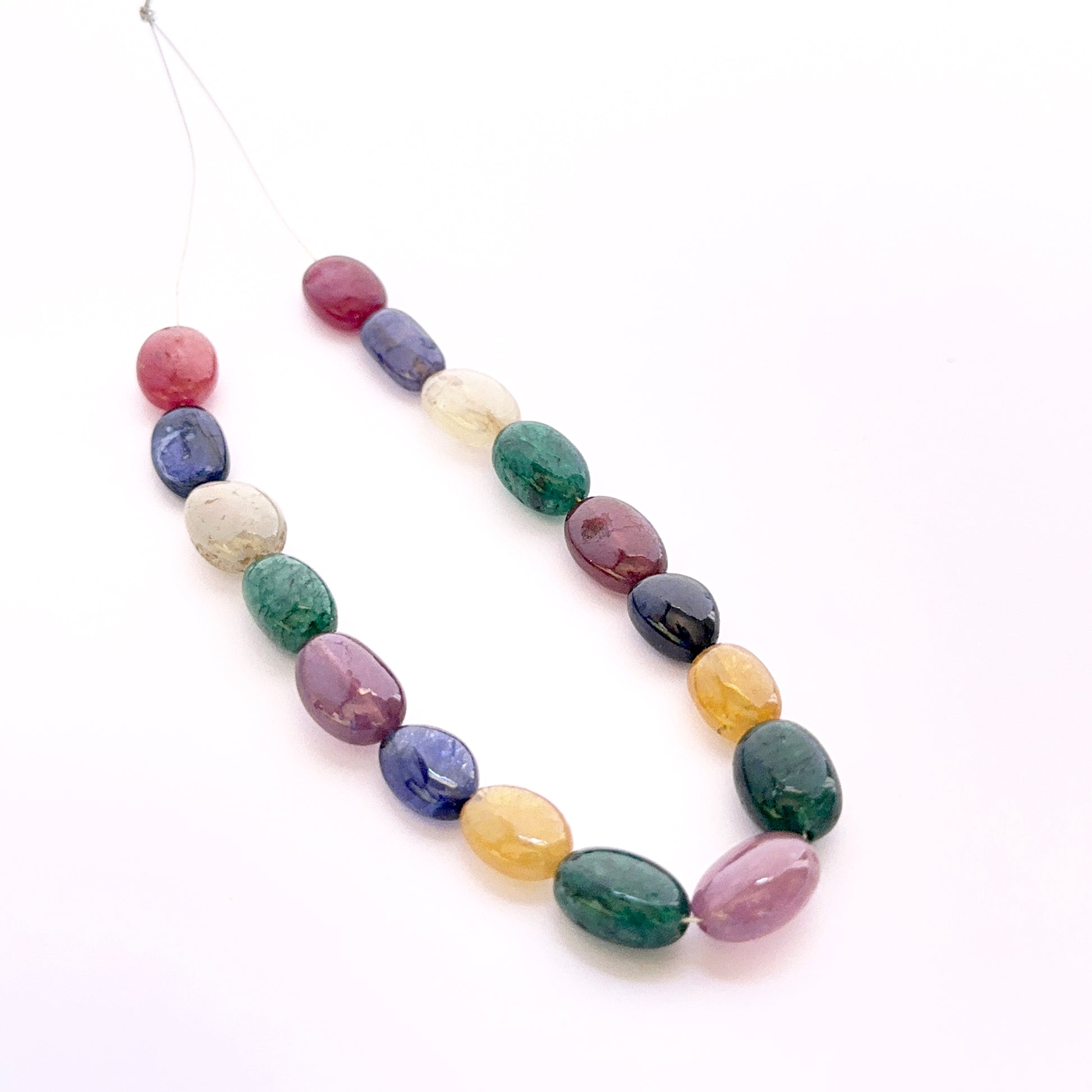 Multi stone smooth oval beads 9x7–11x9mm featuring yellow sapphire, ruby, blue sapphire and emerald, 17 pieces, 81 carats.