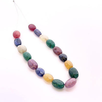 Multi stone smooth oval beads 9x7–11x9mm featuring yellow sapphire, ruby, blue sapphire and emerald, 17 pieces, 81 carats.
