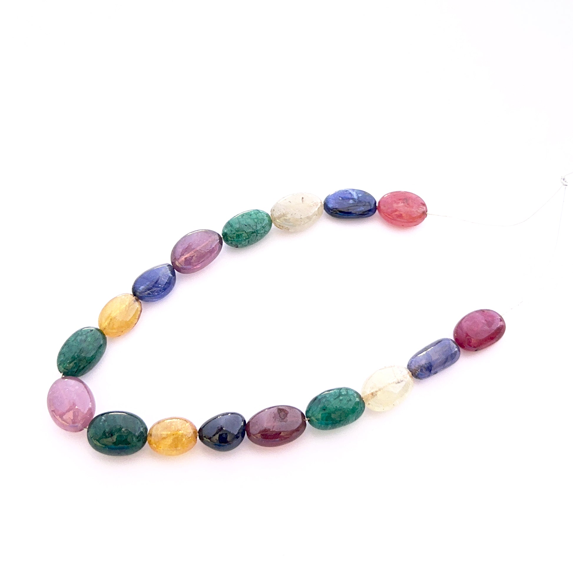 Smooth oval yellow sapphire, ruby, blue sapphire and emerald beads arranged to display uniform shape and rich gemstone hue