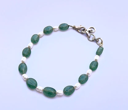 Emerald and pearl bracelet with smooth oval beads showing shine.