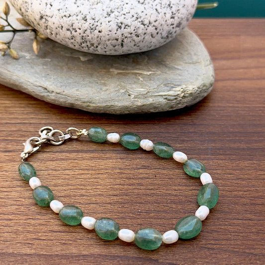 Emerald and freshwater pearl bracelet featuring smooth oval beads in green and white tones.