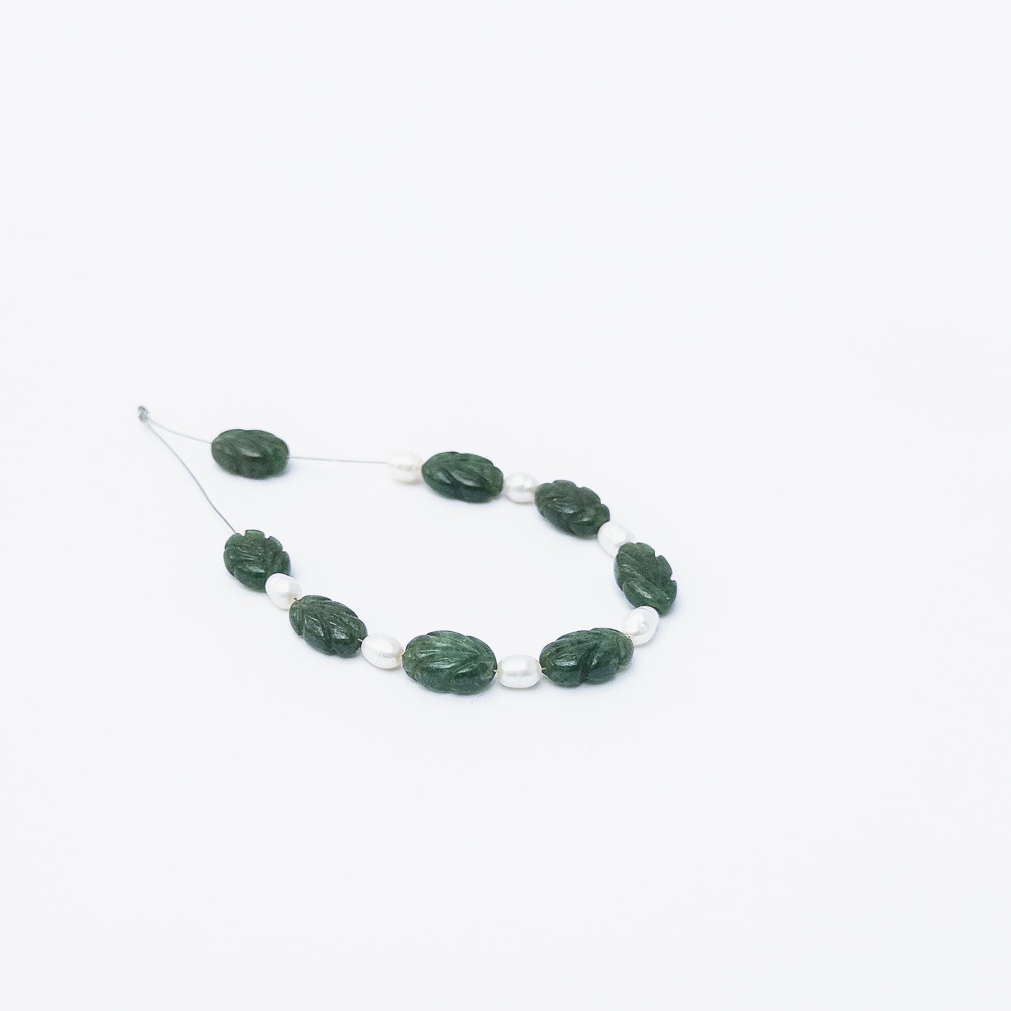 Close‑up of Emerald carved beads and Freshwater Pearls highlighting their polished texture and elegant mixed‑gem look.
