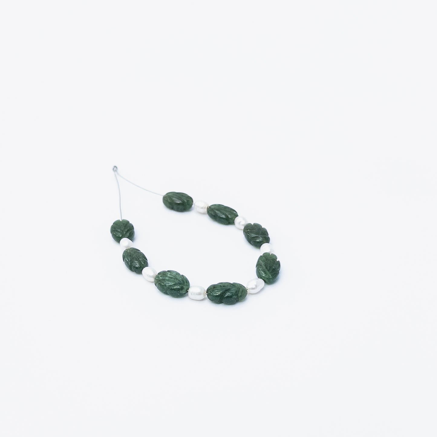 Handmade jewellery components featuring carved Emerald beads with Freshwater Pearls for a refined artistic finish.