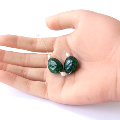 A person holds delicate strands of Emerald and freshwater pearl smooth tumble beads, showcasing their polished design.