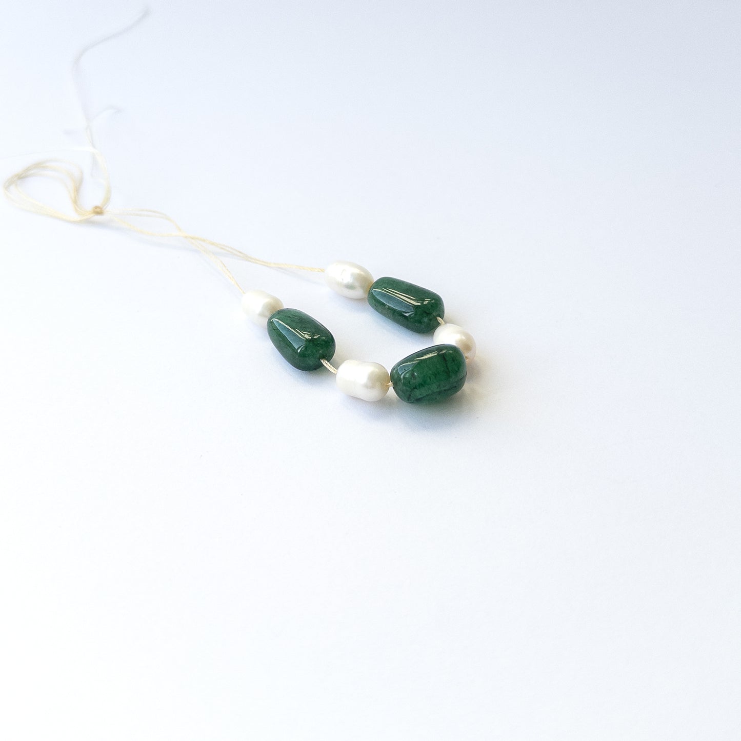 Handmade jewellery components using premium Emerald and freshwater pearl tumbles with elegant green and white tones.