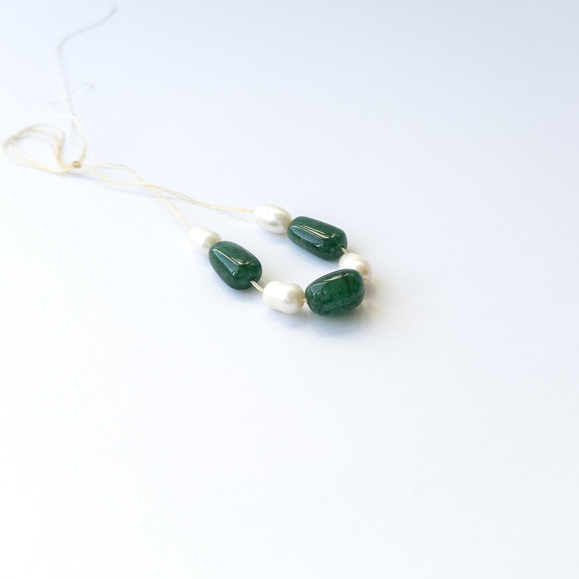 Handmade jewellery components using premium Emerald and freshwater pearl tumbles with elegant green and white tones.