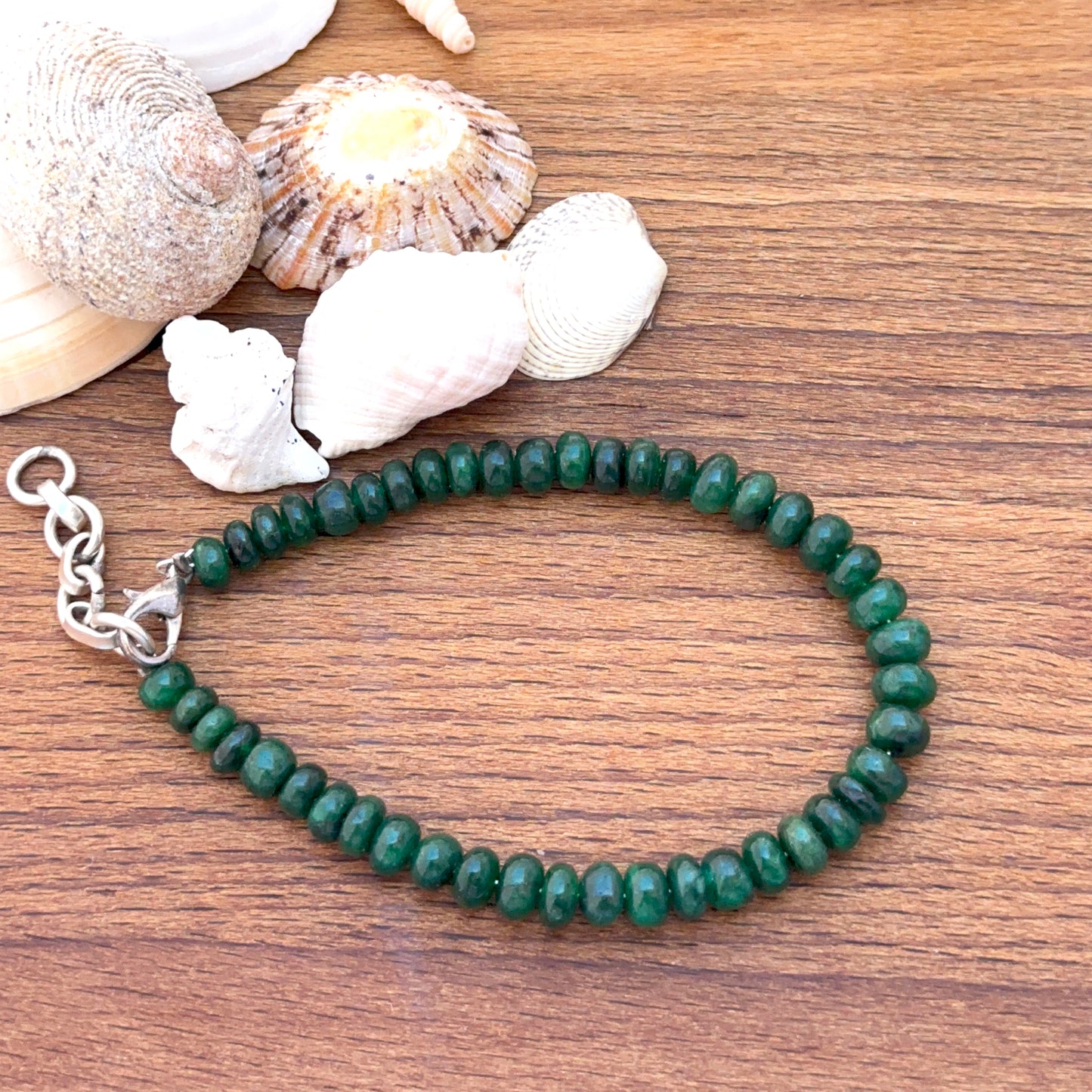 Emerald bracelet featuring smooth rondelle beads in deep green tones.