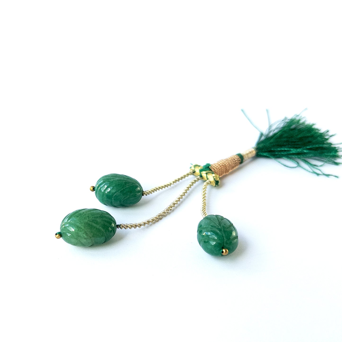 Authentic emerald gemstone beads showcasing rich green tones and intricate carved detailing.