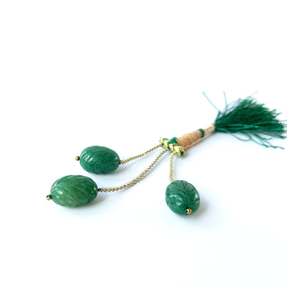 Authentic emerald gemstone beads showcasing rich green tones and intricate carved detailing.