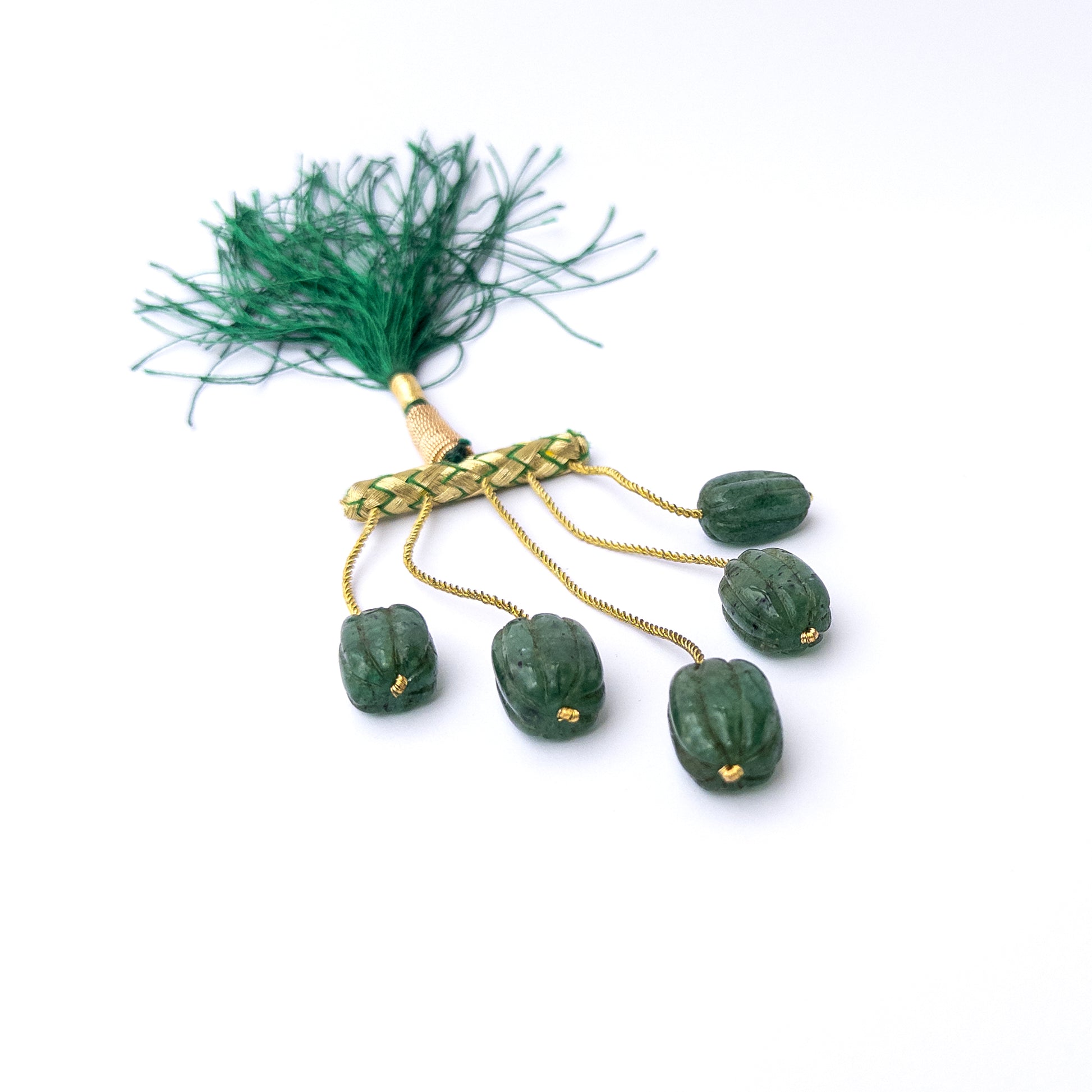 Authentic emerald gemstone beads showcasing rich green colour and intricate carved craftsmanship.