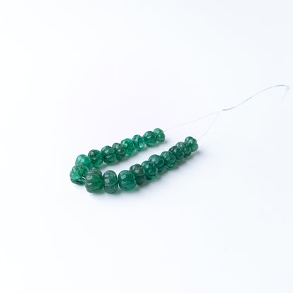Emerald carved pumpkin gemstone beads showcasing vibrant green hues with detailed carving and exceptional gemstone character.