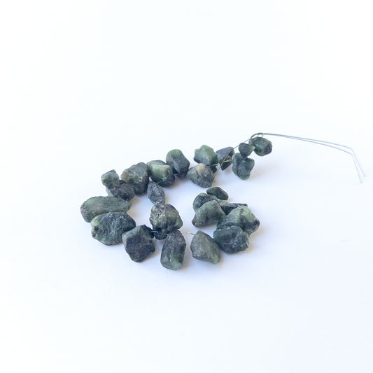 Authentic Emerald rough beads with organic texture arranged in a 21‑piece set for DIY jewellery creators.