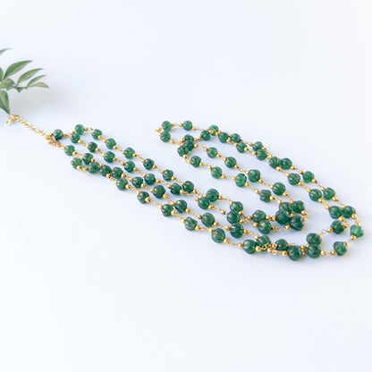 Emerald pumpkin‑cut beads 5.5–6mm showing rich green colour and carved shine in a 2‑strand necklace set.