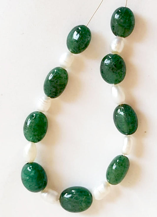 Emerald and freshwater pearl oval beads in smooth cut displaying lustrous green and creamy white tones