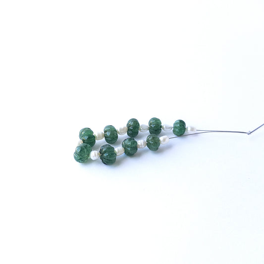 Authentic emerald and freshwater pearl beads showcasing rich green tones and lustrous white accents.