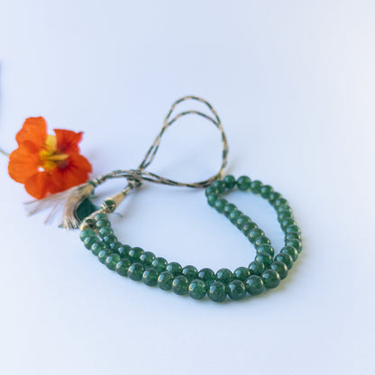 Close up of Emerald gemstone beads showing polished round shapes and vibrant green colour for crafting projects.