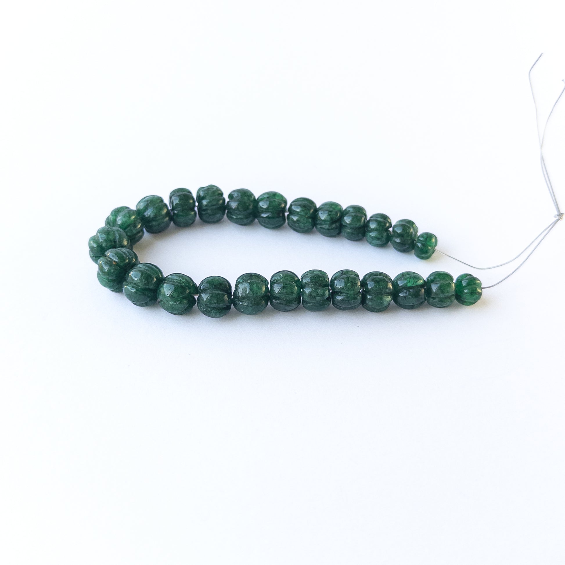Handmade jewellery components with natural emerald pumpkin‑cut beads arranged in a 25‑piece set.