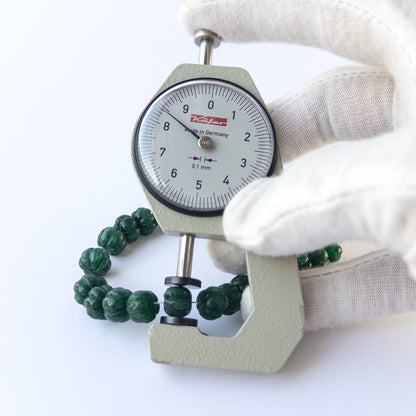 A dial gauge measures the Emerald pumpkin‑cut 6.8–10mm gemstone.